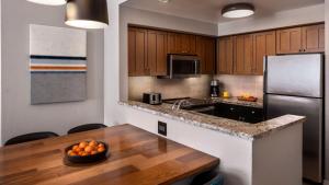 a kitchen with a table and a stainless steel refrigerator at Marriott Mountainside Luxury 1BD in Park City +31 photos