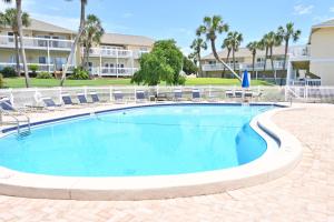 a swimming pool with chairs and a building at Sandpiper Cove Unit 8125 Updated Studio In Destin FL in Destin