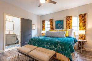 a bedroom with a bed with a green comforter at Southtown 3BR Cowboy Pool, Playset, Riverwalk, BBQ, Firepit, Big Yard — Downtown San Antonio in San Antonio +67 photos