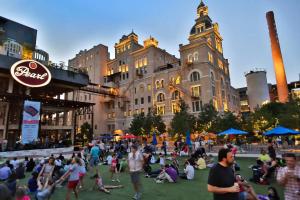 a crowd of people sitting on the grass in front of a building at Southtown 3BR Cowboy Pool, Playset, Riverwalk, BBQ, Firepit, Big Yard — Downtown San Antonio in San Antonio