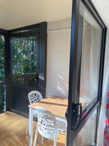 a table and chairs on a porch with a sliding glass door at Joe & Mary's Comfy homestay room in Auckland +6 photos