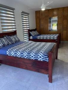two twin beds in a room with wooden walls at Villa Plasencia! in El Tetero +27 photos