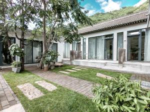 a house with a garden in front of it at Beijing Wuji Inn - The Great Wall of China Huanghuacheng in Beijing