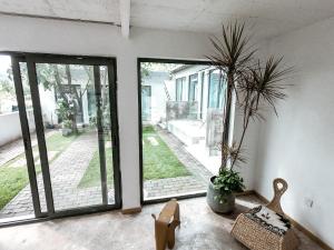 a room with sliding glass doors and a plant at Beijing Wuji Inn - The Great Wall of China Huanghuacheng in Beijing