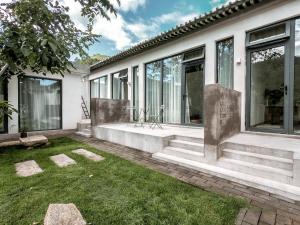 a house with windows and a grass yard at Beijing Wuji Inn - The Great Wall of China Huanghuacheng in Beijing