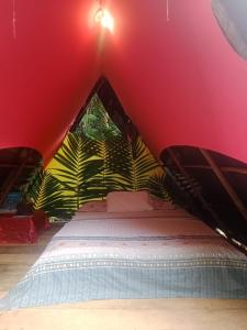 1 dormitorio con 1 cama en una pared roja en Eco Hospedaje Ata Ladrilleros, en Buenaventura