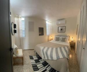 a white bedroom with a bed and a window at Casa Valentina Dreamy Beach Lakeview House in Punta Santiago
