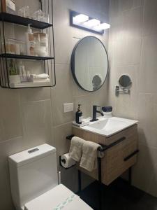 a bathroom with a toilet and a sink and a mirror at Casa Valentina Dreamy Beach Lakeview House in Punta Santiago