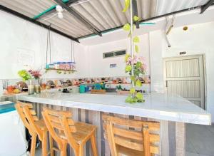 a kitchen with a large counter with wooden chairs at HOTEL HERMOSO CARIBE in Tolú