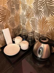 a table with a tea kettle and plates and glasses at AGs Place in Tagbilaran City