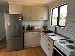 a kitchen with a stainless steel refrigerator and a stove at Curlew Cottage Katherine in Katherine