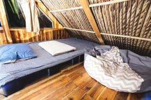 a bed in a wicker room with a pillow and a comforter at Cactos Chill & Homestay in Ho Chi Minh City