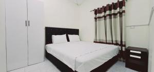 a bedroom with a bed with a black and white headboard at Aurora Mirage Apartments in Nadi