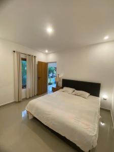 a bedroom with a large white bed and a window at Sidehouse in Badung