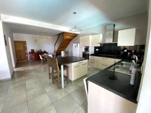 una cucina con un tavolo e un piano di lavoro di Grande villa belle vue lagon kazcaillou a Saint-Paul