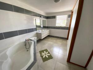 un bagno con vasca e lavandino di Grande villa belle vue lagon kazcaillou a Saint-Paul