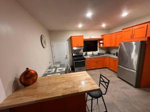 a kitchen with orange cabinets and a wooden counter top at Sunrise Apartments in Rosarito