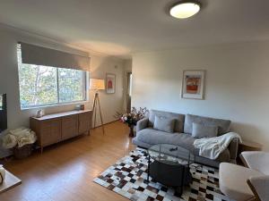 a living room with a couch and a window at Cute & Light-filled Apartment - near Liverpool CBD in Liverpool
