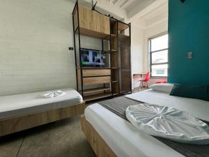 two beds in a room with a tv on a wall at Hotel Living Box San Fernando Cali in Cali