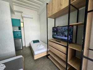 a small room with a tv and a room with a bed at Hotel Living Box San Fernando Cali in Cali