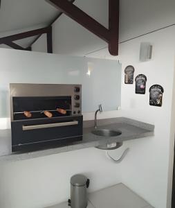 eine Küche mit Herd und Spüle in der Unterkunft Flats confortáveis no Laguna Beach in Porto De Galinhas