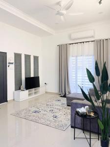 a white living room with a couch and a tv at Melur House - Private Pool, Jacuzzi, Bbq, Netflix, PS4 in Malacca +37 photos