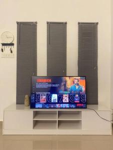a flat screen tv sitting on top of a table at Melur House - Private Pool, Jacuzzi, Bbq, Netflix, PS4 in Malacca