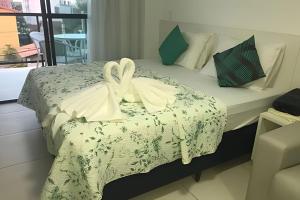 a bedroom with a bed with two white towels on it at Flat Luxo no Laguna Beach in Porto De Galinhas +25 photos