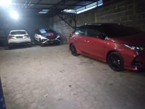 two cars are parked in a garage at Griyo Kartika backpacker in Probolinggo