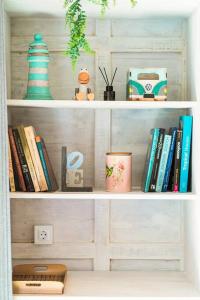 ein Bücherregal mit Büchern und anderen Artikeln darauf in der Unterkunft SooBali Mint Cottage Sanur 1BR in Sanur