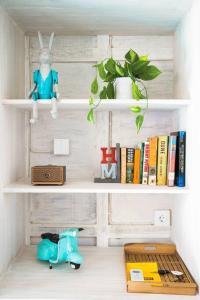 ein Bücherregal mit einem Spielzeugkaninchen und Büchern in der Unterkunft SooBali Mint Cottage Sanur 1BR in Sanur