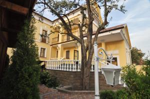 Sudar Hotel في تولا: منزل اصفر امامه شجره