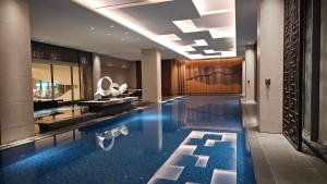 a lobby with a swimming pool in a hotel at Branz Apartement BSD City by Nagisa Bali in Kramat