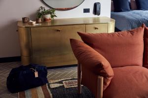 a living room with a chair and a dresser at Paramount House Hotel in Sydney