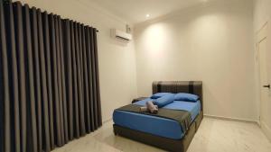 a bedroom with a bed with blue pillows and curtains at Mar'wanis Villa Homestay Beaufort Sabah in Bambangan +18 photos