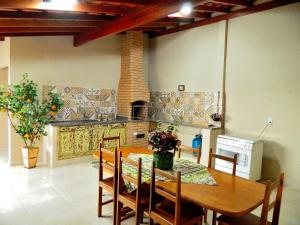 - une cuisine avec une table en bois, des chaises et une cuisinière dans l'établissement Casa Recanto do Maestro ll, à Olímpia