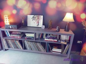 a white book shelf filled with records and a lamp at Villa Manni Koh Phangan in Koh Phangan