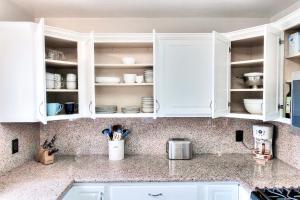 a kitchen counter with white cabinets and utensils at Beachside Bliss Spacious 3BR Retreat, Steps to Ocean in Oceanside +22 photos