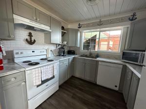 a white kitchen with white appliances and a window at Westport Inn in Westport