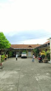 a car parked in a parking lot in front of a building at Hotel Kawsar Syariah in Negara