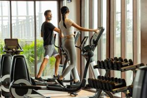 a man and a woman on a treadmill in a gym at Holiday Inn Resort Bali Canggu by IHG in Canggu