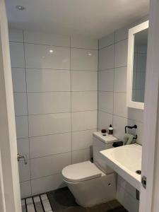 a white bathroom with a toilet and a sink at A modern two bedroom apartment! Quiet, secure and 1 minute walk to Bondi Beach! in Sydney +13 photos