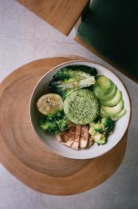 un piatto di cibo con broccoli e cetrioli su un tavolo di Wave House Resort Canggu a Canggu