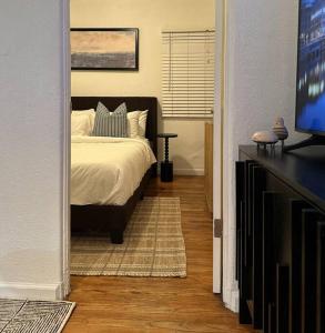 Un dormitorio con una cama y un televisor de pantalla plana. en Modern Eclectic 1BR by Downtown, Airport & More, en San Diego