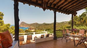 a porch with a table and chairs and a view of the ocean at New! Villa Salada Sea Views in San Antonio +35 photos
