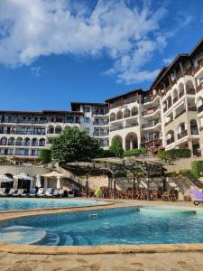 a hotel with a swimming pool in front of a building at Manastira-2 (A-3) in Sveti Vlas