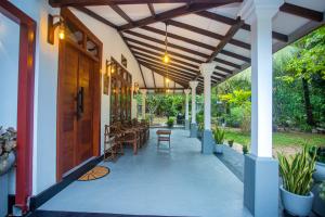 a porch of a house with a wooden door at 2BR Family Getaway Hikkaduwa- Sleep 6 - Surfing- Bikes and airport drop-off in Hikkaduwa