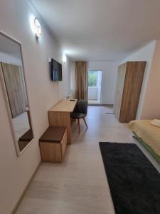 a hotel room with a desk and a bedroom at Vila Roxana Busteni in Buşteni