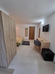 a room with a bed and a desk and a room with a bed at Vila Roxana Busteni in Buşteni +19 photos