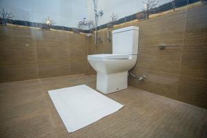 a bathroom with a toilet and a white rug at 2BR Family Getaway Hikkaduwa- Sleep 6 - Surfing- Bikes and airport drop-off in Hikkaduwa